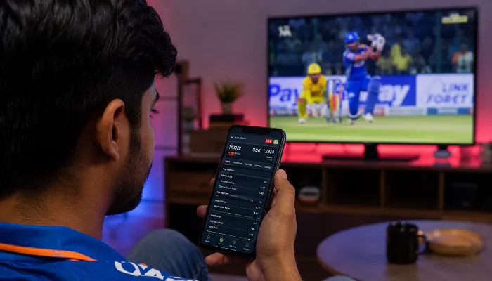 Young Indian user checking live cricket betting odds on smartphone during IPL match